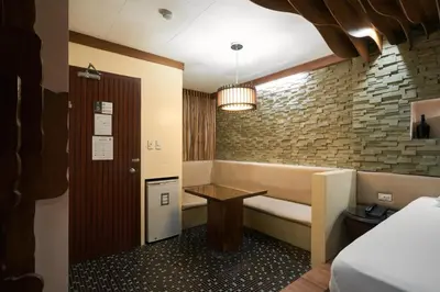 a room with a bench and a table in it at Victoria Court Suites - Pasig in Manila