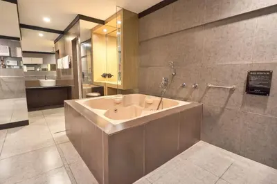 a large bathroom with a tub and a shower at Victoria Court Las Pinas in Manila