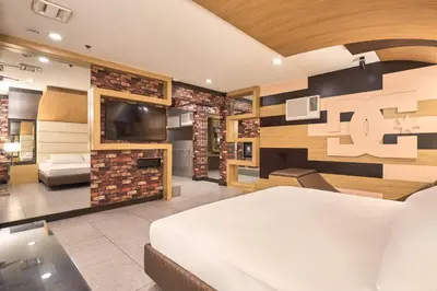 a hotel room with a bed and a tv at Victoria Court Las Pinas in Manila