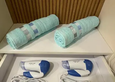 a shelf with two towels and a pair ofippers at Casa Rhea in Manila