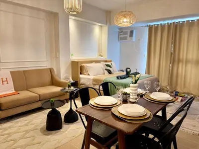 a living room with a table and a couch at Cozy Staycation Venice with Balcony Mckinley near Bgc in Manila