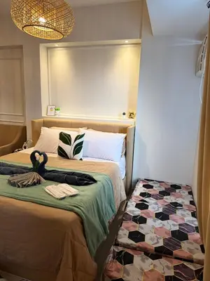 a bedroom with two beds and a checkerboard floor at Cozy Staycation Venice with Balcony Mckinley near Bgc in Manila