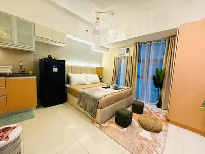 a small bedroom with a bed and a kitchen at Staycation near Venice Mall mckinley taguig in Manila