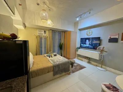 a bedroom with a bed and a flat screen tv at Staycation near Venice Mall mckinley taguig in Manila