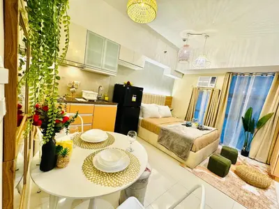 a kitchen and a living room with a table in a room at Staycation near Venice Mall mckinley taguig in Manila