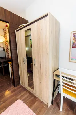 a wooden cabinet with a mirror in a room at Chic Romantic Getaway Makati Studio One BR Two BR Swim Gym 300 MB in Manila