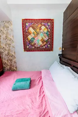 a bedroom with a pink bed and a painting on the wall at Chic Romantic Getaway Makati Studio One BR Two BR Swim Gym 300 MB in Manila