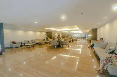 a lobby with people sitting on couches and tables at Chic Romantic Getaway Makati Studio One BR Two BR Swim Gym 300 MB in Manila