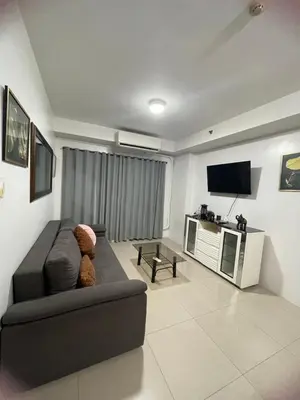 a living room with a couch and a flat screen tv at Moa view with big balcony 558 in Manila