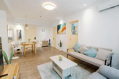 a living room with a couch and a table at Cozy 2-Bedroom at South of Market SOMA BGC near SM Aura, Market! Market! & Bonifacio High Street in Manila
