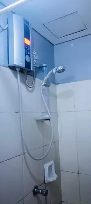 a shower with a hose in a bathroom with a toilet at Avida sm sucat quest house condo hotel in Manila