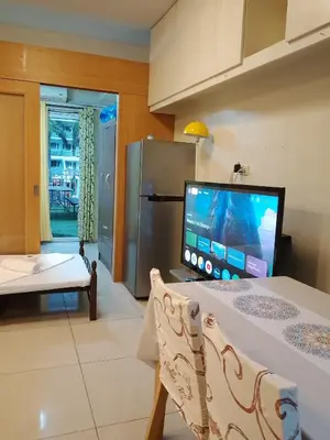 a living room with a flat screen tv and a couch at 232D pool view with big balcony in Manila
