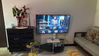 a living room with a flat screen tv on the wall at Staycation with city lights in Manila
