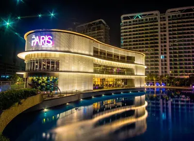 a large building with a reflection in the water at night at Azure Urban Resort Staycation in Manila