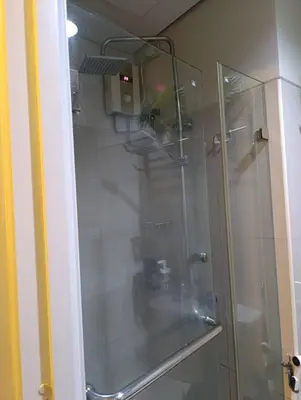 a shower with a glass door in a bathroom at Shell Residences - MOA in Manila