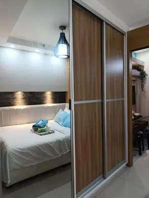 a bedroom with a bed and a sliding glass door at Shell Residences - MOA in Manila