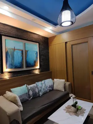 a living room with a couch and a table at Shell Residences - MOA in Manila