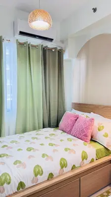 a bedroom with a bed with green curtains at Japanese Inspired Hotel at MOA in Manila