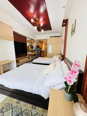 a large bedroom with two beds and a kitchen at 2 Bed's Unit at PICC Near MOA in Manila