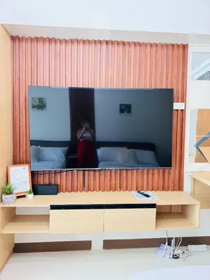 a person taking a picture of a large screen television at 2 Bed's Unit at PICC Near MOA in Manila