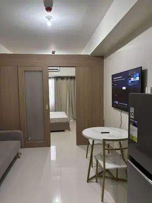 a living room with a table and a tv at Shore Residence Tower 1 Staycation in Manila