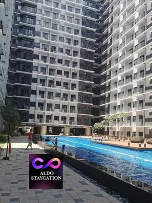 a large apartment building with a large swimming pool at Shore 3 tower 2 mall of Asia staycation in Manila