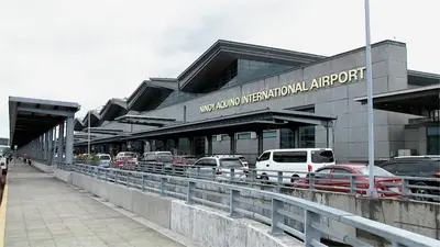 a parking lot with cars parked in front of an airport at Mall Of Asia - Shore Apartments in Manila