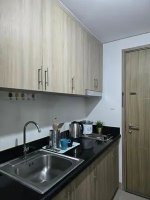 a kitchen with a sink and a counter top at Mall Of Asia - Shore Apartments in Manila