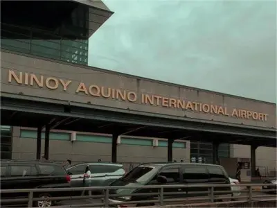 a building with cars parked in a parking lot at Mall Of Asia - Shore2 Residences in Manila