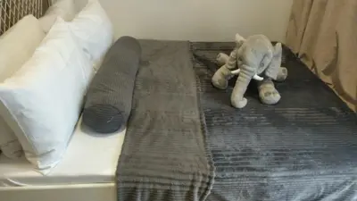 a stuffed elephant is laying on a bed at SMDC Fame Condo in Manila