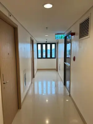 an empty hallway of an office building with a exit sign at Smdc green 2 residence in Pasong Bayog