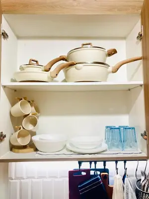 a shelf with pots and pans and other dishes at Serene Stays at Shore in Manila