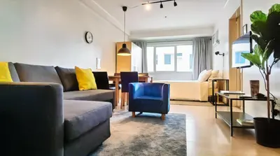 a living room with a couch and a blue chair at Private Modern Condo in BGC in Manila