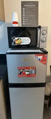 a microwave sitting on top of a refrigerator at Shore Residence by CozyHaven's Homestay in Manila