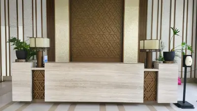 a reception desk in a hotel lobby with two lamps at The Atherton- Spacious Modern Condo Unit in Paranaque Near the Airport, Makati, BGC and Highways in Manila