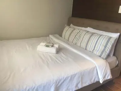 a white bed with a stuffed animal sitting on it at Casa Beatrice Staycation in Manila