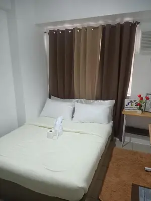 a bed with a white bow on top of it at Urban deca tower by jas airways in Manila