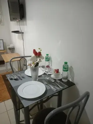 a table with plates and glasses and flowers on it at Urban deca tower by jas airways in Manila