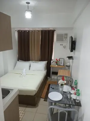a small room with a bed and a table at Urban deca tower by jas airways in Manila
