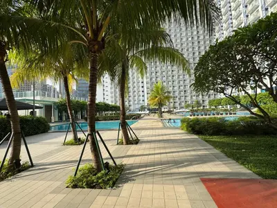 a sidewalk with palm trees in a city with buildings at Jazz Residences Makati in Manila