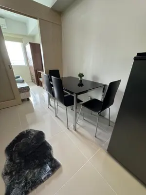 a dining room with a black table and chairs at Jazz Residences Makati in Manila