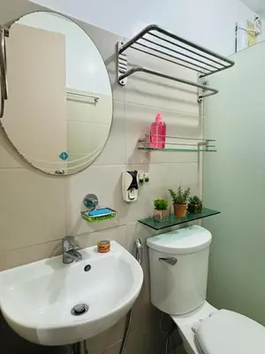 a bathroom with a sink and a mirror and a toilet at Casa Lily in Manila