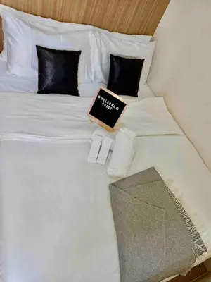 a laptop sitting on top of a white bed at 1BR Room-Stunning MOA view FIREWORKS in Manila