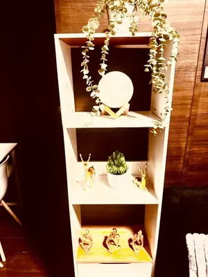 a white shelf with figurines and a plant on it at Luxurious 2 Bedroom Oasis in Air Residences with Bar KTV and Games in Manila
