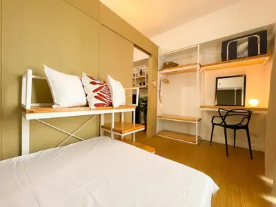 a bedroom with a bed and some shelves with pillows at Houzz 1548 by Houzztelity in Manila