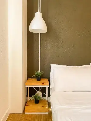 a bedroom with a bed and a table with a lamp at Houzz 1548 by Houzztelity in Manila