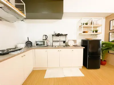 a kitchen with white cabinets and a black refrigerator at Houzz 1548 by Houzztelity in Manila