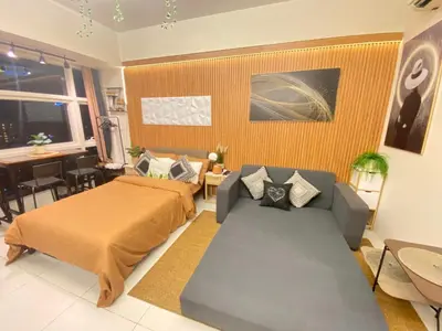 a living room with a bed and a couch at Twin Oaks near MRT Shaw, Megamall, Shangri-la plaza in Manila