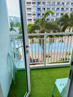 a balcony with a chair and a view of the beach at 2 bedroom just accross MOA and SMX by jam ez in Manila