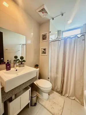 a bathroom with a sink and a toilet and a shower at City Lights Apartment in BGC in Manila